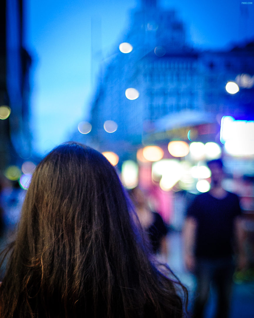 Young lady walking on the streets of New York City, Madison Avenue. The background is blurred with smooth Bokeh.
