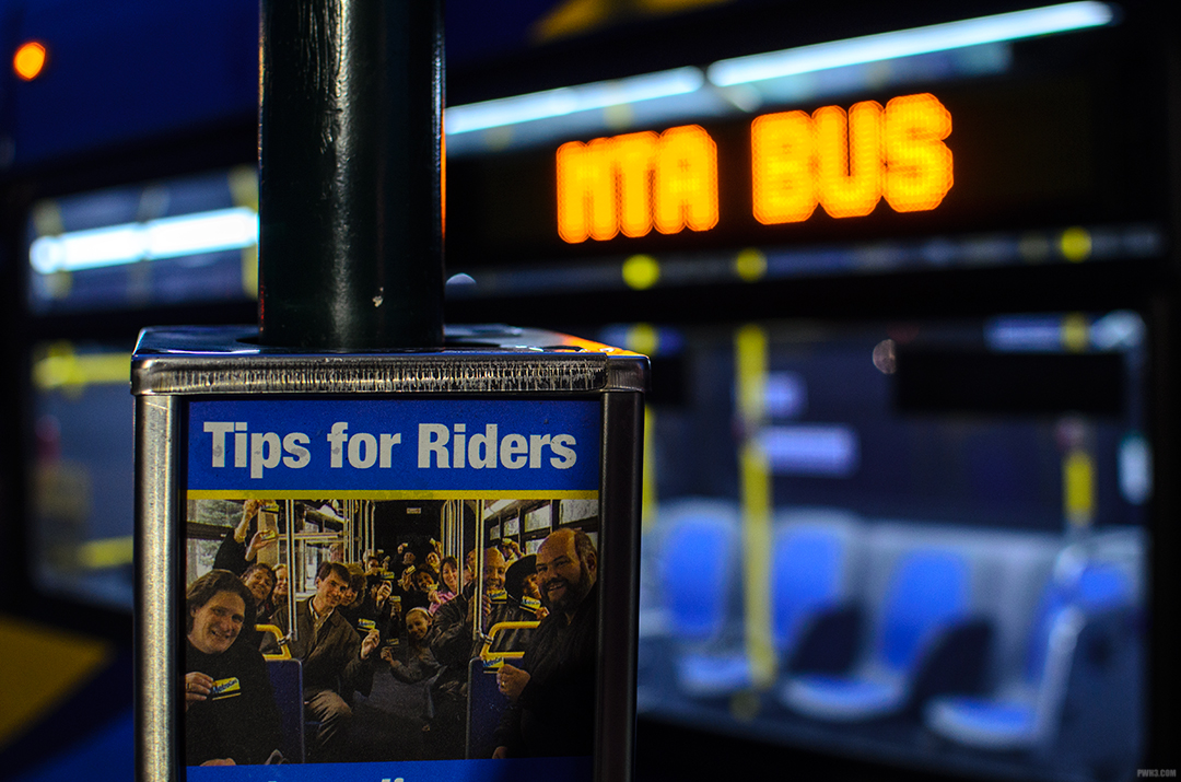 MTA "Tips for Riders" sign in front of the digital  "MTA bus" sign on an empty bus.